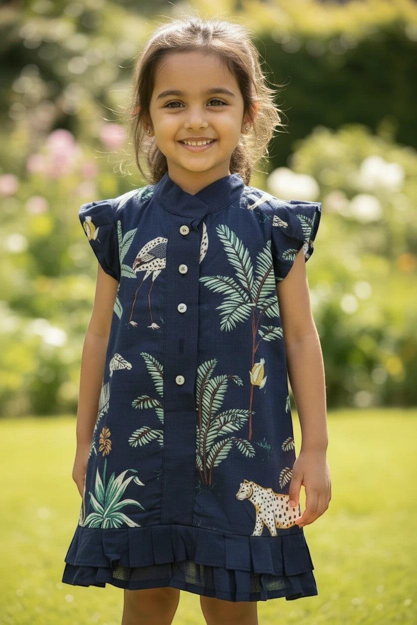 Kakapo Kids navy blue jungle print dress with ruffle sleeves and hem, featuring flamingos, leopards, and tropical foliage.